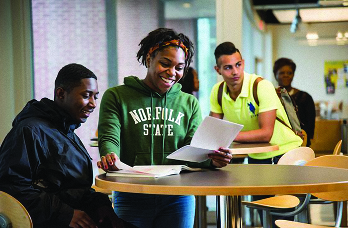 students sit at tables in a study area